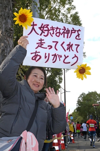 神戸愛にあふれたメッセージでランナーを応援する女性＝２０２３年１１月１９日、神戸市長田区