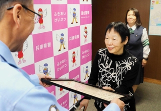 金月照幸署長（左）から感謝状を受け取る田中瞳さん＝中央区吾妻通５、葺合署