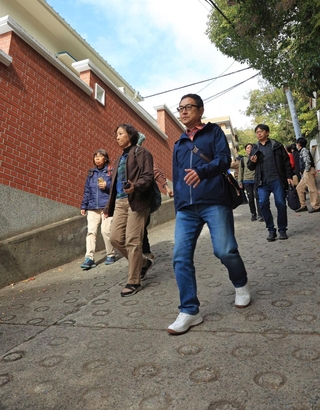 市街地の坂を歩く参加者ら＝中央区諏訪山町