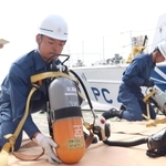 空気ボンベを装着する海上保安官ら＝神戸市中央区新港町