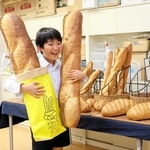 「意外と重い」と約１メートルの大きなフランスパンを抱える児童