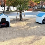 東遊園地の「芝生ひろば」に設置されている芝刈りロボット。犬小屋に見立てた待機所が通行人から注目を集める＝中央区加納町６