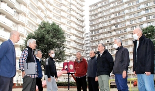 耐震改修工事が完了したポートアイランド住宅の前で、談笑する管理組合の役員ら＝神戸市中央区港島中町３