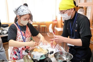 水を節約するため、食材を耐熱性のポリ袋に入れて調理する参加者ら＝神戸市兵庫区駅南通５