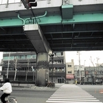 コンクリートが剝がれて曲がった鉄骨がむき出しになった阪神高速神戸線の橋脚と、３階部分がつぶれたビル＝１９９５年１月１８日（和田幹司さん撮影、神戸アーカイブ写真館提供）