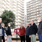 耐震改修工事が完了したポートアイランド住宅の前で、談笑する管理組合の役員ら＝神戸市中央区港島中町３