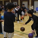 ２個のボールを使ったドリブルの練習法を伝える大学生＝神戸大（提供写真）