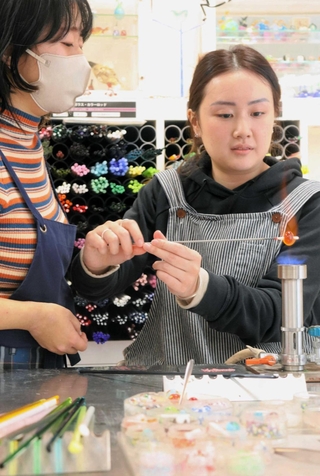 「１・１７希望の灯り」の分灯を使ってとんぼ玉を制作する来場者＝神戸市中央区京町