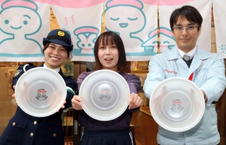 風呂おけを手にする湊河湯の松田悠さん（中央）とデンソーテンの江川雅裕さん（右）＝神戸市兵庫区東山町２