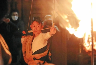 暗がりの中、矢を的の中心に命中させた澤田友樹さん＝神戸市北区淡河町勝雄、淡河八幡神社