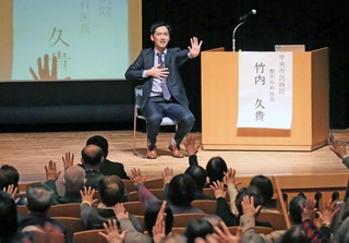 観客と一緒に手や指の体操をする整形外科医長の竹内久貴さん＝神戸新聞松方ホール