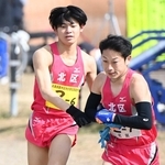 男子・北区の６区古賀三大選手（左）からたすきを受け取る７区山本翔馬選手＝加古川市の加古川河川敷マラソンコース（撮影・斎藤雅志）