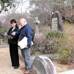 神戸市公園部森林整備事務所の榊原均さん（右）の案内で神戸市立外国人墓地を調べる長谷川純子さん＝同市北区山田町