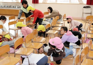 椅子の下に入って身を守る園児ら＝神戸市中央区吾妻通４