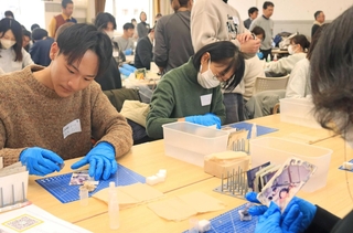 災害で浸水した写真を丁寧に拭く参加者ら＝神戸北野ノスタ