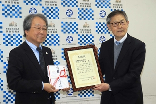 神戸市社会福祉協議会から感謝状を贈られた世良美術館の濱崎庄一館長（右）＝こうべ市民福祉交流センター