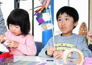 紙コップなどでこいのぼりを手作りする子どもたち＝さかなの学校
