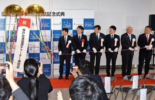 国際便就航を祝う式典で、くす玉を割る関係者ら＝18日午前、神戸市中央区、神戸空港（撮影・丸山桃奈）