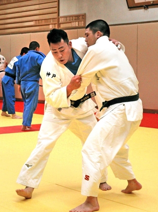 現役の部員（右）と組み合う古田伸悟教諭＝育英高校