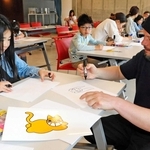 ワークショップで作った黄色いネコのオリジナルイラストを街中に貼る参加者＝中央区新港町