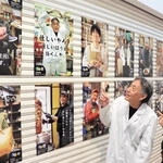 店主の個性あふれるポスターを眺める文勝弘さん（左）と立元香さん＝中央区北長狭通、ピアザ神戸
