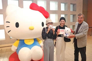３万人目の入場者として記念品を受け取る藤山早悠里さん（中央）と友人の伊敷亜也加さん（左）＝神戸ゆかりの美術館