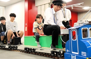ミニ電気鉄道に乗車する生徒と参加した子どもたち＝神戸市立科学技術高校