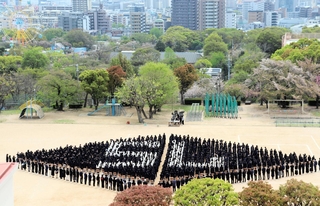約１２００人が整列して校章のひし形を描いた。市街地から見ると周年の「７５」が浮かび上がる＝神戸海星女子学院