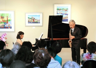 前身の世良美術館を設計した建築家の瀬戸本淳さん（右）がサックスを演奏し、リニューアルを祝った＝みかげ芸術堂