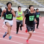 １００メートル競走で全力疾走する選手ら＝ユニバー記念競技場
