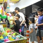 露店をのぞき、目を輝かせる子どもら＝阪神青木駅前