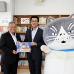 中島竜也社長（中央）から絵本を受け取る赤木裕之校長＝神戸市灘区備後町1