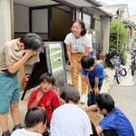 東京から新長田に移住し、開設予定のアトリエ前で子どもたちと話す織戸ゆみこさん＝神戸市長田区二葉町２
