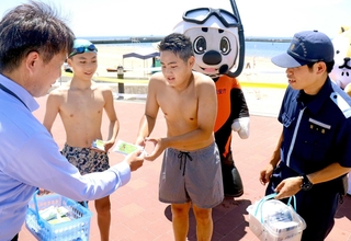 海水浴客に違法薬物の危険性を訴える兵庫県警の警察官ら＝須磨海水浴場