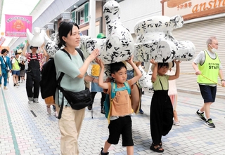 灘中央市場の開設１００年を祝い、周辺の商店街で行われたパレード＝灘区水道筋３