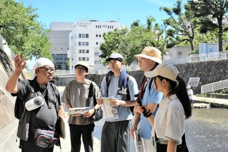 碓井和貴さん（左端）の案内で都賀川水難事故の現場を歩く神戸大の学生ら＝灘区篠原南町５