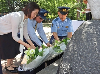 慰霊碑に花を手向ける岸上佳代区長（左端）ら＝灘区神ノ木通４