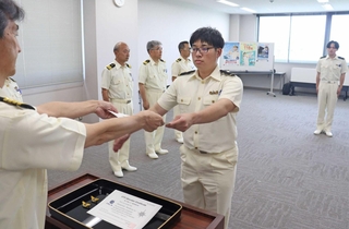 管制官の認定証を受け取る佐藤優大さん＝大阪湾海上交通センター