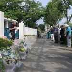 校門前に花を並べ、黙とうをささげる参加者ら＝神戸市西区美賀多台９