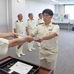 管制官の認定証を受け取る佐藤優大さん＝大阪湾海上交通センター
