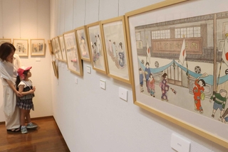 戦前の街並みや戦中の空襲などを描いた作品が並ぶ会場＝こうべまちづくり会館