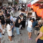 地蔵の前で手を合わせ、菓子を受け取る子どもたち。親子連れらが長い列を作った＝長田区庄田町３