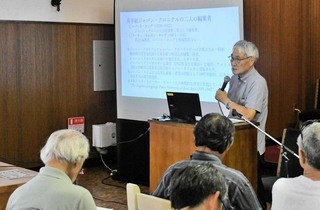 戦前に神戸で発行されていた「ジャパン・クロニクル」について解説する洲脇一郎さん＝外国人墓地礼拝堂