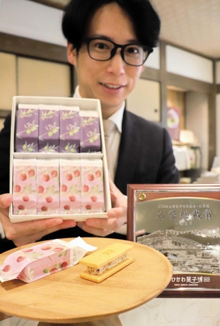 全国菓子大博覧会で受賞した商品を示す松井隆昌社長＝亀井堂総本店