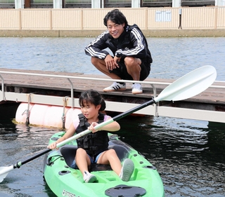 カヌーをこぐ子どもたちを見守る羽根田卓也さん＝三井アウトレットパーク　マリンピア神戸