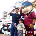 ヴィッセル神戸のマスコット「モーヴィ」と一緒に救急車両の前で記念写真に納まる子どもら＝ノエビアスタジアム神戸
