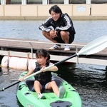 カヌーをこぐ子どもたちを見守る羽根田卓也さん＝三井アウトレットパーク　マリンピア神戸