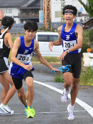 男子・葺合の１区坂口智明選手（右）からたすきを受け取る２区吉﨑昭汰選手＝丹波篠山市内（撮影・丸山桃奈）