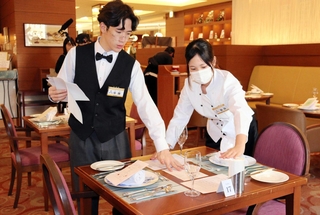 ナイフやフォークをセッティングし、ディナーの準備を進める生徒ら＝ホテル北野プラザ六甲荘