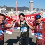 同郷の仲間とともに完走し、タオルを掲げる樋口正明さん（中央）＝神戸市中央区東川崎町１（撮影・鈴木雅之）